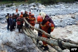 中国四川甘孜泸定县发生6.8级地震后,救援人员在救助当地居民。(2022年9月5日)