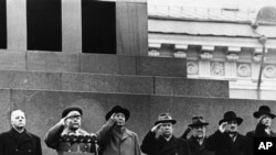 1957年11月11日毛泽东在莫斯科红场(左三)与苏联最高领导人站在列宁墓前敬礼。左起为苏联国家元首德米特里·伏罗希洛夫;国防部长罗季翁·马利诺夫斯基元帅,毛泽东;苏联共产党主席尼基塔·赫鲁晓夫;总理尼古拉·布尔加宁;副总理阿纳斯塔斯·米高扬;和执政主席团成员苏斯洛夫
