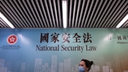 行人走过香港街头港版国安法的宣传牌。(2020年7月28日)
