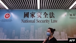 行人走过香港街头港版国安法的宣传牌。(2020年7月28日)