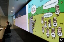 香港警务处国安处官员李桂华(左)在记者会上指控香港言语治疗师总工会5名理事发布“羊村”系列儿童绘本为煽动罪。 (2021年7月22日)