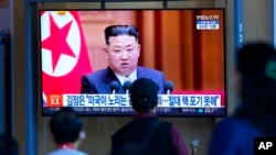 2022年9月9日,在韩国首尔的首尔火车站,人们在观看电视屏幕上播放的新闻节目,其中有朝鲜领导人金正恩的影像资料。