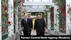 朝鲜中央通讯社2024年6月20日发布的这张图片显示,俄罗斯总统弗拉基米尔·普京和朝鲜领导人金正恩在朝鲜平壤锦绣山宾馆的花园里散步时做出反应。(朝中社,路透社)