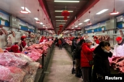 北京新发地农产品批发市场的肉类摊主在卖猪肉。(2024年2月2日)