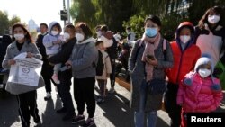 北京儿童医院外排队等候看病的儿童与家长。(2023年11月24日)