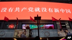 资料照:北京一家商场树立的宣传牌上写着“没有共产党就没有新中国”的口号。(2015年2月6日)