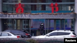 资料照片:上海浦东金融区的上海证券交易所大楼外面站着一名保安。(2020年2月3日)