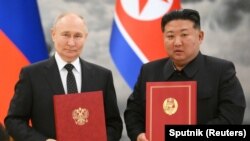 俄罗斯总统普京与朝鲜领导人金正恩在平壤举行的签字仪式上合影。(2024年6月19日)