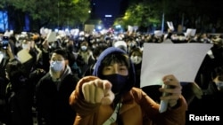 资料照:北京的年轻人手举白纸上街示威,抗议新冠清零封控政策。(2022年11月27日)
