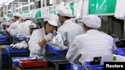 资料照片:中国广东东莞一家生产锂离子电池的工厂工人在生产线上。(2022年10月16日)