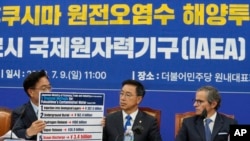 2023年7月9日,在韩国首尔举行的一次会议上,议员禹元植展示了福岛污染水的拟议处理方法,议员魏圣坤和国际原子能机构总干事拉斐尔·格罗西(右)在一旁观看。