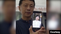 唐吉田律师和他手机里女儿的照片,2021年拍摄。(唐吉田律师关注组提供)