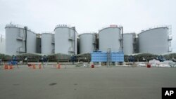2023年7月14日,在日本二叶町的福岛第一核电站,一条黑色管道沿着装有处理过的放射性废水的水箱延伸。