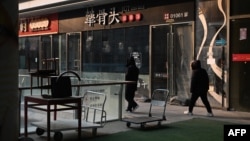 人们走过北京一处商业区关闭的餐馆。(2024年1月29日)