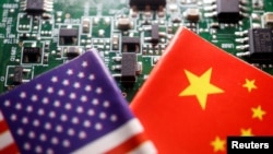 资料照片:这张拍摄于2023年2月17日的照片中,中美两国国旗展现在带有半导体芯片的印刷电路板上。(路透社照片)