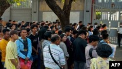 People gather outside the embassy of Thailand to get visas in Yangon on February 16, 2024, after Myanmar's military government said it would impose military service.