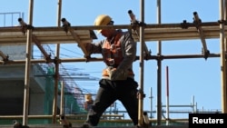 2024年1月26日,一名建筑工人站在北京一处工地的脚手架上。(路透社照片)