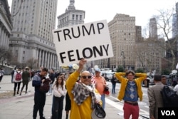美国前总统特朗普的反对者在纽约法院外举牌反对特朗普。(2023年4月4日)