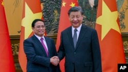 资料照片:中国国家主席习近平在北京同越南总理范明正握手。(2023年6月27日)