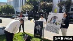 2月10日,活动参与者在洛杉矶中领馆门口向李文亮遗像鞠躬悼念。(2024年2月10日,张木林洛杉矶拍摄)