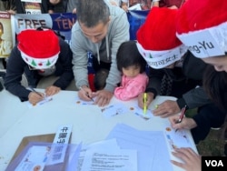 在洛杉矶中国领事馆门前马路对面的桌子上,人们通过写明信片送祝福的方式,表达对牛腾宇及他的母亲,以及在中国受到政府关押的政治犯的关心。(美国之音 张木林)