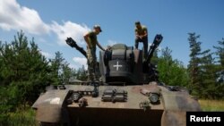 在乌克兰基辅州,乌军士兵在作战间歇站在德制“猎豹”自行高射炮上交谈。(2023年6月30日)