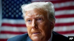 资料照片:2023年6月1日,美国前总统唐纳德·特朗普在爱荷华州得梅因举行的西区保守党早餐会上与支持者交谈。