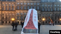 2023年六四周年前夕,荷兰阿姆斯特丹水坝广场前抗议人士展示“国殇之柱”横幅(林生亮提供)