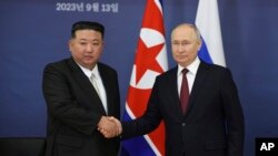 资料照片:2023年9月13日,俄罗斯总统普京和朝鲜领导人金正恩在俄罗斯齐奥尔科夫斯基市外的东方航天发射场会晤时握手。(美联社照片)