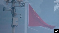 资料照:中国军队士兵在被雾霾笼罩的天安门广场升起国旗。(2019年3月5日)
