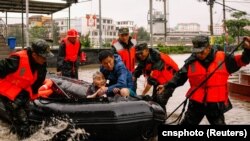 Paramilitary police officers evacuate residents stranded by floodwaters in Xincuo town of Fuqing city, after Typhoon Doksuri made landfall and brought heavy rainfall in Fuzhou, Fujian province, China, July 29, 2023.