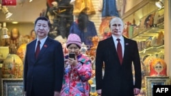 资料照片:莫斯科街头一家旅游纪念品商店外树立的中俄领导人纸板画像。(2023年11月15日)