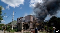 乌克兰消防员正在南部赫尔松地区为一栋被俄罗斯炮击摧毁的民房灭火。(2023年7月1日)