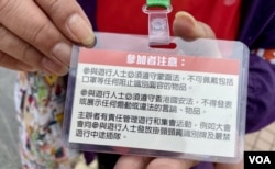 将军澳反填海游行纠察赵小姐展示挂颈号码牌背面,印有参加者注意事项,包括必须遵守“禁蒙面法”、香港国安法,以及沿途不可以插队等 (美国之音/汤惠芸)
