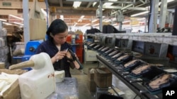 资料照片:2023年2月7日,一名妇女在墨西哥莱昂的一家制鞋厂工作。(美联社照片)