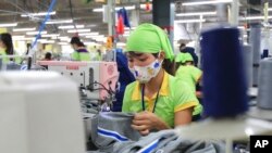 资料照片:2017年10月24日,一名工人在越南南定省的一家运动衣工厂缝制服装。(美联社照片)
