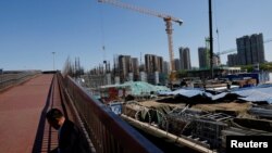 一名男子坐在北京一处建筑工地旁。(2023年4月18日)