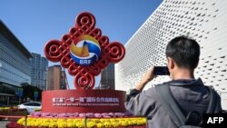 一名男子在北京宣传一带一路论坛的路标前拍照。(2023年10月16日)