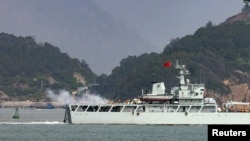 资料照:在靠近台湾金门岛的福建省福州附近海域一艘中国海军战舰在举行军演时开火。(2023年4月8日)