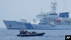 资料照片:在美国、日本和菲律宾三边海岸警卫队演习期间,一艘菲律宾海警的硬底橡皮艇经过日本海上保安厅的“秋津洲”号。(2023年6月6日)