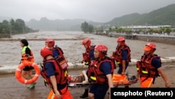 中国救援人员在北京门头沟区救助遭洪水泛滥袭击的民众。(2023年8月1日)