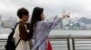 两名中国年轻人五一节前到香港游玩时在小红书上寻找旅游攻略。(2024年4月30日)