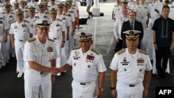 美国第七舰队司令卡尔·托马斯中将(左)和菲律宾海军 2023“萨玛萨玛”演习司令官托里比奥·阿达西中将(中)在美菲年度海军演习的开幕式上握手。(2023年10月2日)
