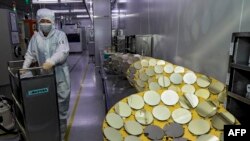 资料照片:中国江苏省淮安的一个半导体芯片厂的工人在做工。(2024年4月29日)
