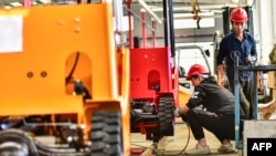 中国山东省青州一个铲车厂的工人正在生产铲车。(2023年10月27日)