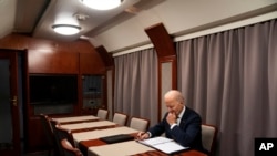 资料照片:2023年2月20日,拜登总统突访乌克兰在基辅与乌克兰总统泽连斯基见面后,在火车上审阅纪念乌克兰战争一周年的演讲稿。(美联社照片)