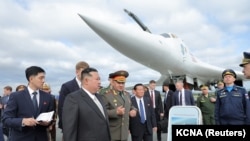 资料照片:朝鲜领导人金正恩在俄罗斯国防部长绍伊古陪同下参观符拉迪沃斯托克军事基地的核轰炸机。(2023年9月16日)