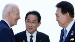 2023 年 5 月 21 日,在日本广岛举行的七国集团峰会期间,美国总统拜登在三边会议之前与日本首相岸田文雄和韩国总统尹锡悦(右)交谈。