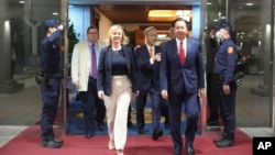 在台湾外交部发布的照片中,2023年5月16日英国前首相利兹·特拉斯抵达台湾桃园机场时,与台湾外交部长吴钊燮一起行走