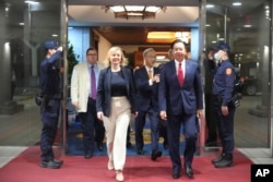 在台湾外交部发布的照片中,英国前首相利兹·特拉斯2023年5月16日抵达台湾桃园机场时,与台湾外交部长吴钊燮一起行走。(美联社照片)